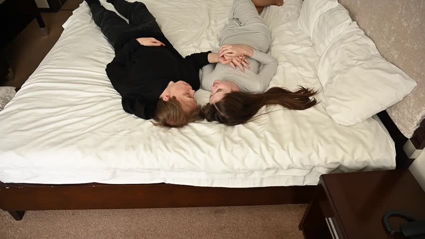 Top view of young caucasian couple hugging on bed. 