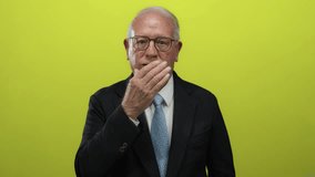 Senior man in a suit making a gesture in front of a vibrant yellow background, conveying emotions with a confident business style. - Powered by Shutterstock - Get 15% off with code: PIKWIZARD15