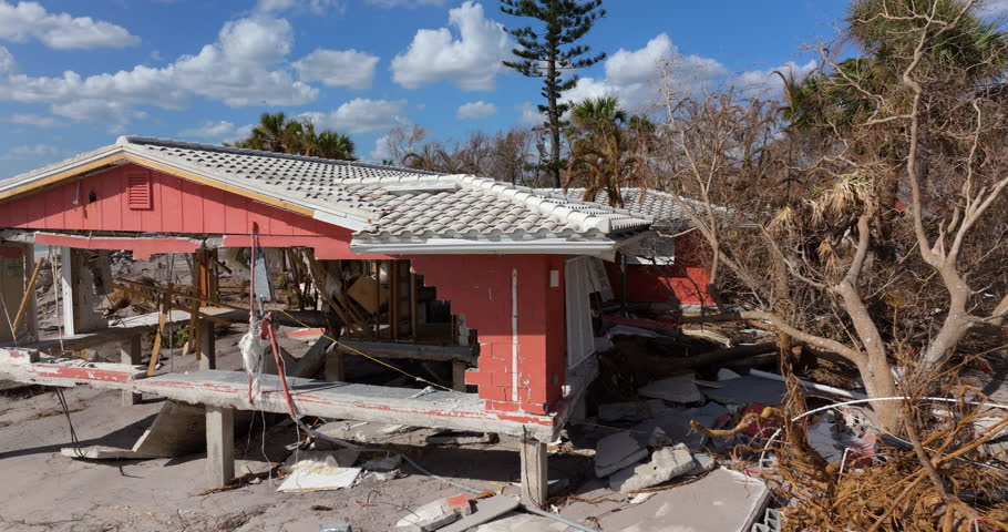 Ruined building in need of demolition or repair. Storm surge water and wind damaged house roof and collapsed walls after hurricane in Florida.