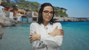 Hispanic woman in white jacket embraces herself joyfully at sunlit seaside, with rocky coastline and clear sea as background, showcasing serene outdoor relaxation. - Powered by Shutterstock - Get 15% off with code: PIKWIZARD15