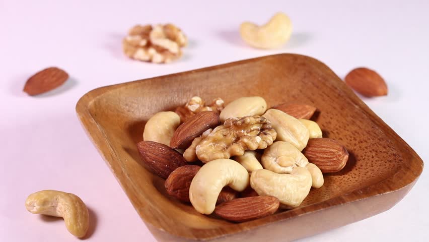 Mixed nuts served in a wooden bowl, rotating