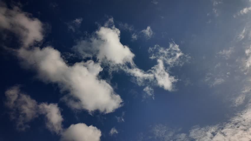 Bright blue sky with fluffy white clouds on a sunny and clear day, natural background, inspiring peace of mind.