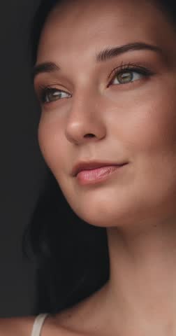 Slow motion portrait of a smiling Caucasian woman with flawless glowing skin and golden makeup in soft studio lighting. Ideal for skincare, beauty concepts, and cosmetic promos.