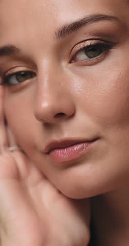 Close-up beauty portrait of a glamorous Caucasian woman with glowing skin and gold eye makeup. High quality studio shot perfect for skincare, beauty ads, or makeup promotions.