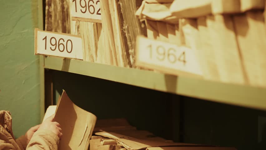 Old classified documents stored on dusty archive shelves in historical records department. Vintage paperwork, archival files, official reports preserved in secure archival. Secret document heritage 