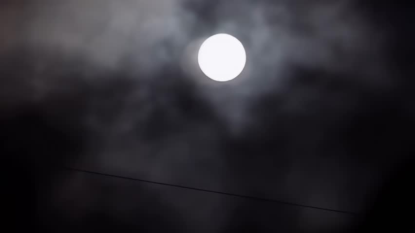 Full Moon Shining Through Moving Clouds at Night