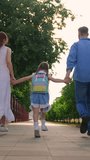 Girl with parents running to school. Children education concept. Child daughter with backpacks, father mother running to school holding hands. Happy family. Mom dad taking child to school along street - Powered by Shutterstock - Get 15% off with code: PIKWIZARD15