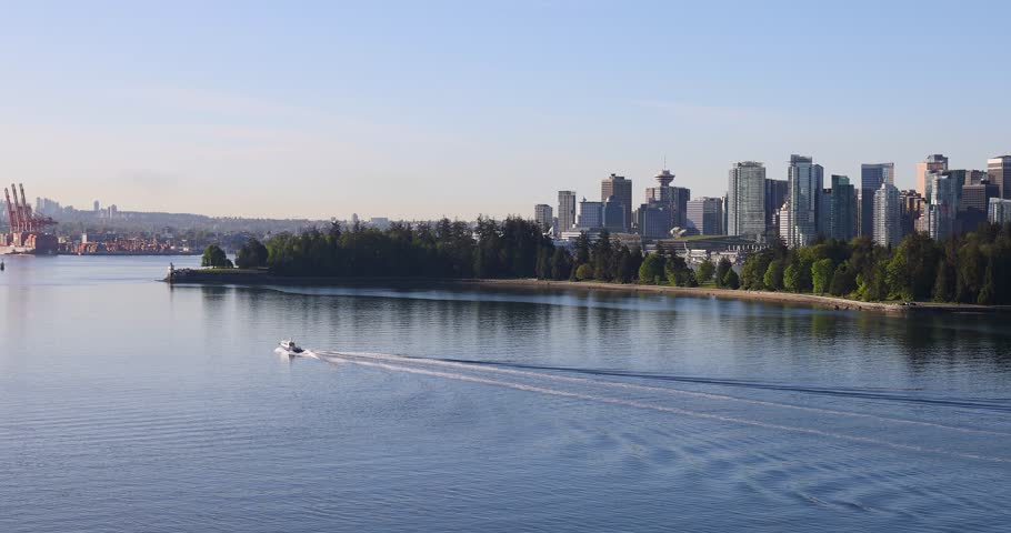 Beautiful Aerial View Of Vancouver City Skyline With A Boat Moving Across The Water