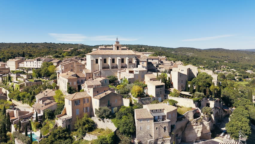 Aerial shot of historic french Gordes villlage on hill during sunny day in Provence, France