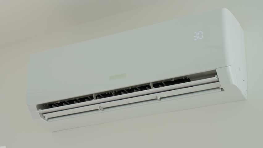 Modern split air conditioner unit installed on wall and cooling apartment. Timelapse with air conditioner flaps moving fast. Concept of indoor climate control and comfortable temperature at home
