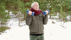 Senior man working out outdoors in winter forest. Person lifting dumbbells. Old male exercising. Healthy people lifestyle. Active sport training. Older elderly sportsman doing fitness. Workout session - Powered by Shutterstock - Get 15% off with code: PIKWIZARD15