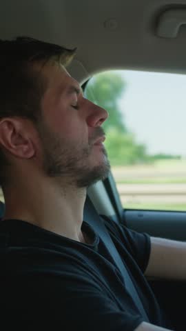 Exhausted person closing eyes and loose concentration behind steering wheel during drive. Tired man falling asleep while driving car on highway road. Concept of driver fatigue and dangerous driving