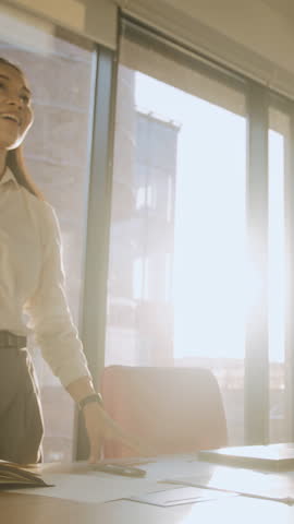 Asian businesswoman shakes hand with man partner in office lit by back sunset. Businesspeople follow etiquette greeting before negotiation in meeting room