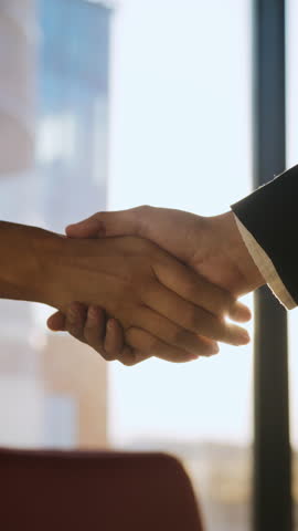 Business partners do handshake showing collaboration and success in modern office lit by sunset sun. Businesspeople make deal meeting in corporate environment closeup