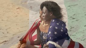 Lifestyle couple unfolding flag behind woman on sandy beach, they wrapping flag sharing moment. Romance, unity, patriotism, serenity, leisure, harmony, connection - Powered by Shutterstock - Get 15% off with code: PIKWIZARD15