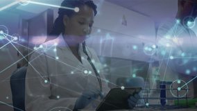 Female scientist tapping tablet screen at lab bench, generating overlay showing research network. Biotech, innovation, technology, collaboration, analytical, futuristic, precision - Powered by Shutterstock - Get 15% off with code: PIKWIZARD15