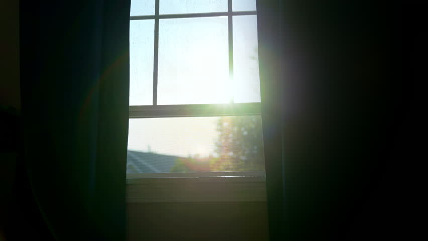 Modern window with decorative muntin is open for fresh air coming. Curtains move by the wind. Sunlight coming in to the room