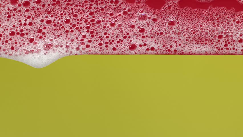 White soap foam bubbles gently move across a yellow and red background in slow motion, creating a clean and calming aesthetic — perfect for hygiene, skincare, spa, product promos, and wellness visuals