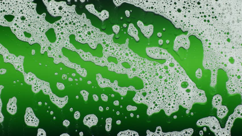 White soap foam bubbles gently move across a green background in slow motion, creating a clean and calming aesthetic — perfect for hygiene, skincare, spa, product promos, and wellness visuals.