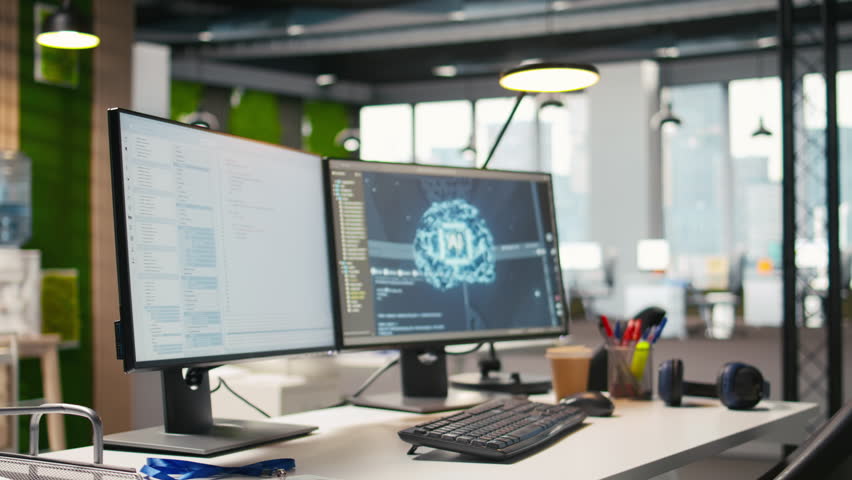 Advanced AI algorithms running on computer monitors in empty startup workspace deploying machine learning models. Artificial intelligence coding platform on PC screens in modern office