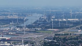 Aerial view of European shipping port full of renewable energy wind turbines, Nuclear Power Plants and fossil fuel distribution - With highway and train tracks running parallel - Ghent Belgium - Powered by Shutterstock - Get 15% off with code: PIKWIZARD15