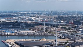Aerial view of European shipping port full of renewable energy wind turbines, Nuclear Power Plants and fossil fuel distribution - With highway and train tracks running parallel - Ghent Belgium - Powered by Shutterstock - Get 15% off with code: PIKWIZARD15