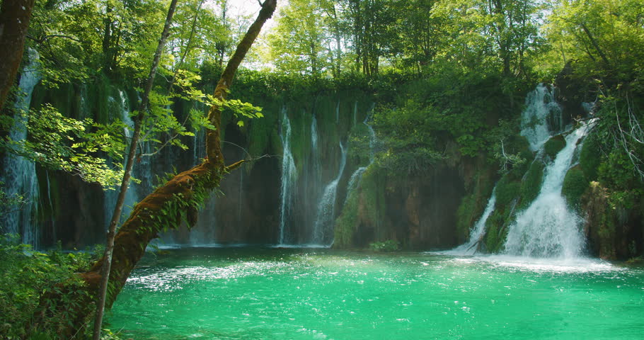 Vibrant waterfalls cascade into turquoise pool at Plitvice Lakes National Park