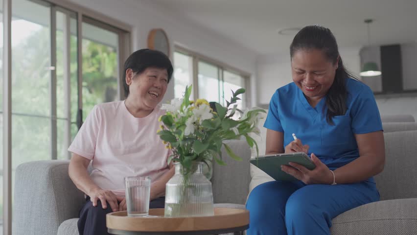 Asian health care worker visiting elderly woman at home, home nurse, home care service concept
