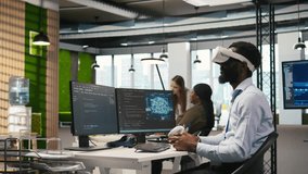 Programmer wearing VR headset at office desk developing programs using AI automation. Startup worker using virtual reality technology, debugging applications with artificial intelligence, camera A - Powered by Shutterstock - Get 15% off with code: PIKWIZARD15