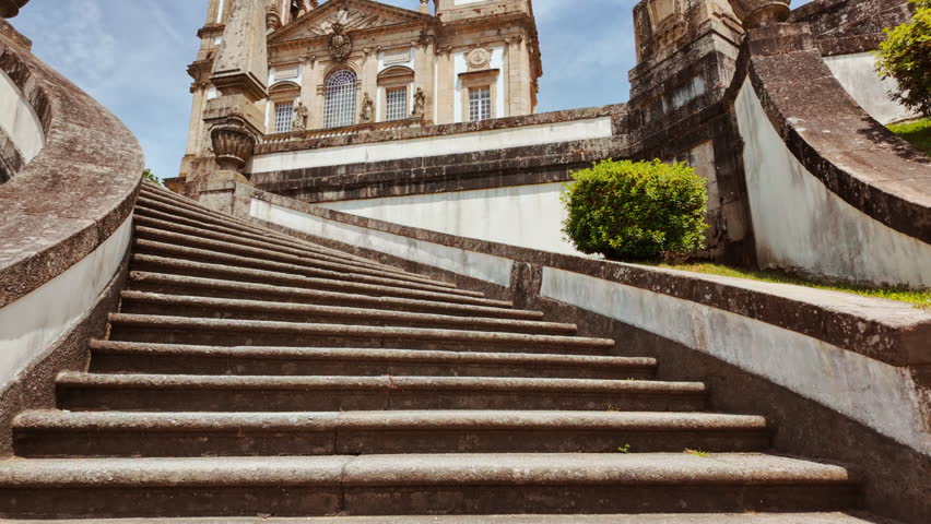 Sanctuary of Bom Jesus do Monte rises above tree canopy its gleaming facade mirrored in lakes and grottoes surrounding Braga, Portugal
