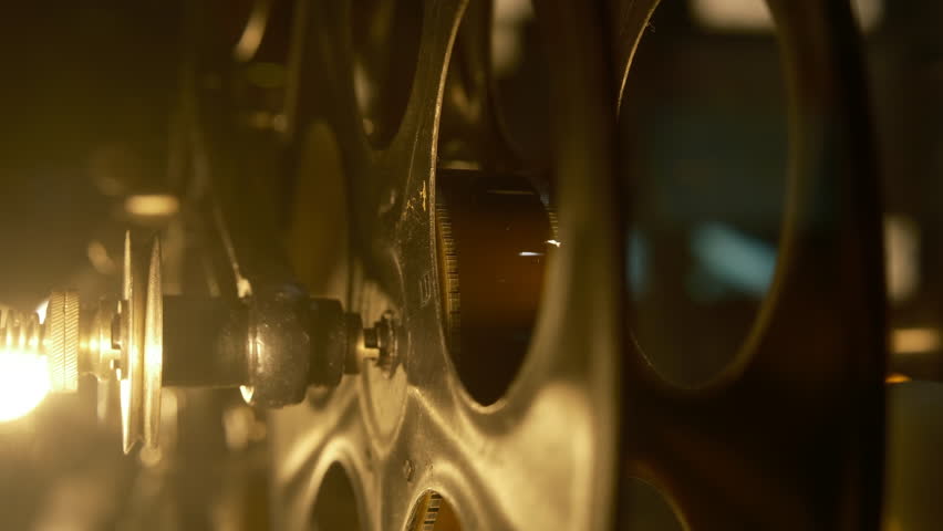 cinematic, old vintage movie projector. of light shines through the lens, illuminating the film reels. The atmosphere classic film screenings. close-up of film footage