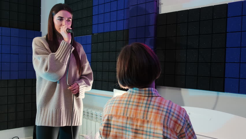 Student voice gains richness and resonance during vocal lesson. Teacher instills deep appreciation for music in young lady in music school slow motion