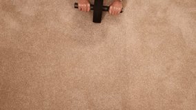 A woman exercises with an abdominal wheel on a carpeted floor, focusing on core strength in a well-lit home setting - Powered by Shutterstock - Get 15% off with code: PIKWIZARD15