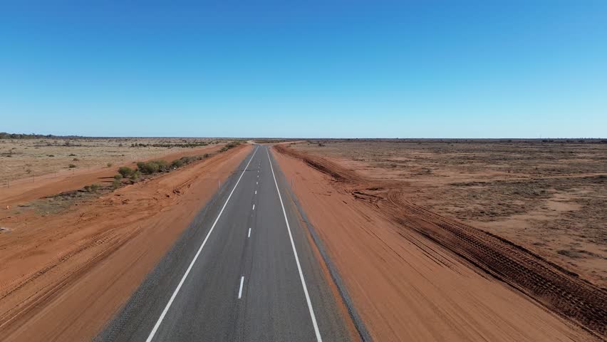 Endless Bitumen Through the Outback
A drone’s-eye view of a lone sealed road cutting through Australia’s vast, rugged outback—endless skies, red earth, and total isolation.