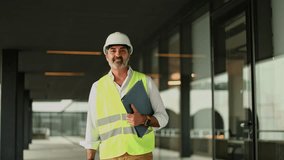 Confident engineer smiling and holding blueprints on a construction site, embodying professionalism and expertise in the industry - Powered by Shutterstock - Get 15% off with code: PIKWIZARD15