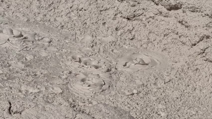 Bubbling mudpot pool of hot splashing mud on the Artists Paintpots Trail in Yellowstone National Park. 