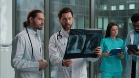 Thoughtful confused two Caucasian men males doctors radiologist and physician holding lungs scan x-ray radiography think diagnosis diagnostic team rehabilitation emergency disease checkup at hospital - Powered by Shutterstock - Get 15% off with code: PIKWIZARD15