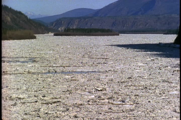 YUKON, ALASKA - CIRCA SEPTEMBER 1996: Churning chunks of ice fill the Yukon River, with mountains in the background.
