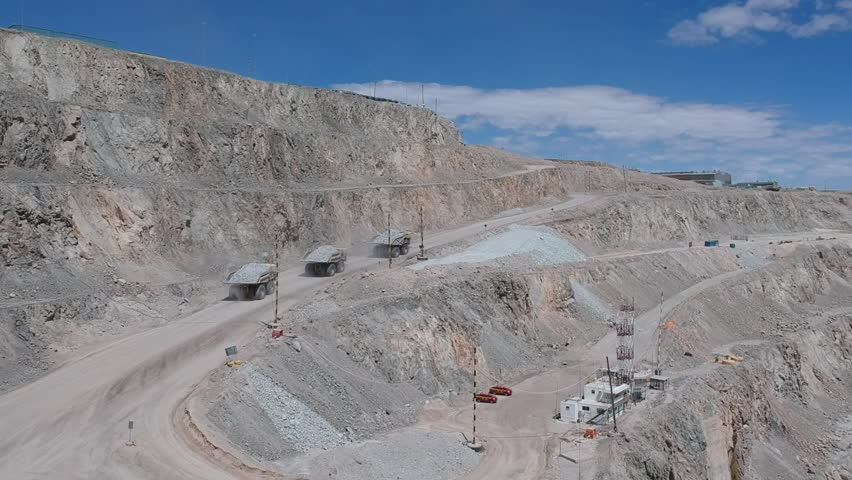 Three mining haul trucks climbing the Chuquicamata mine