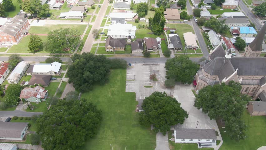 Aerial shot over the Ascension Catholic Church in Donaldsonville, Louisiana, with a flying black bird.
