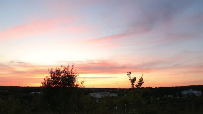 Beautiful sunset sky and tree, branch, bush on silhouette on bright colorful clouds from the high. Yellow orange nature in the evening time at summer season, no people. Natural real colors, untouched