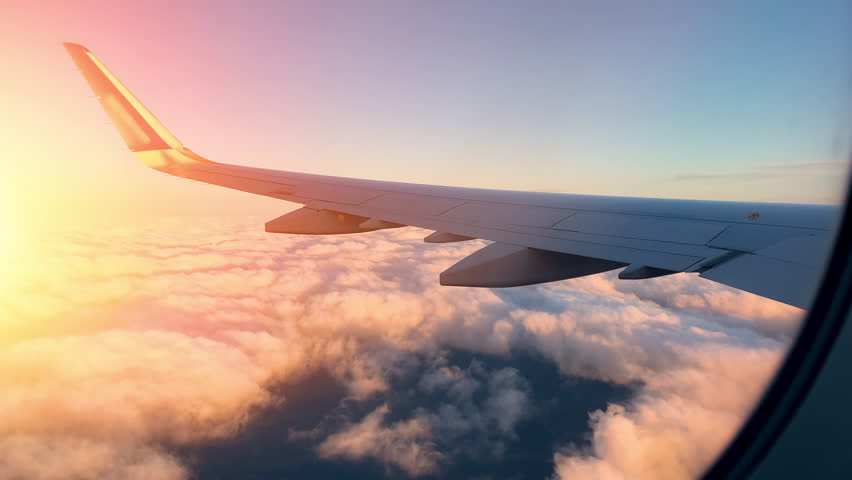 Breathtaking wing view reveals clouds and sunset during an exhilarating flight