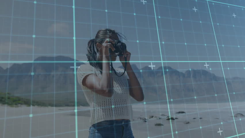 Female photographer raising DSLR and scanning coastline for shot composing with digital focus grid. Adventure, exploration, technology, nature, wilderness, outdoor, creativity
