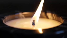 close-up macro shot of a single candle flame burning brightly in the dark. - Powered by Shutterstock - Get 15% off with code: PIKWIZARD15