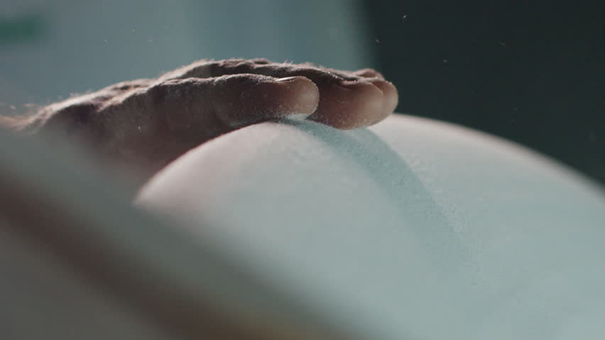 Surfing board shaper works on the surf board factory and creates a surf board. Brazilian shaper touches surfing board and controls its shape in the room on a surfboard factory