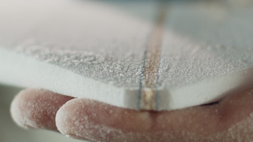 Surfing board shaper works on the surf board factory and creates a surf board. Brazilian shaper produces surfing board on a surfboard factory