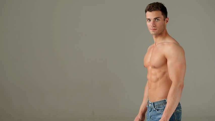 Handsome Muscular Man in Jeans Showing His Muscles