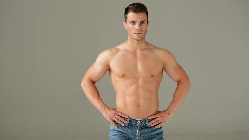 Muscular Man Showing His Biceps Against Gray Background