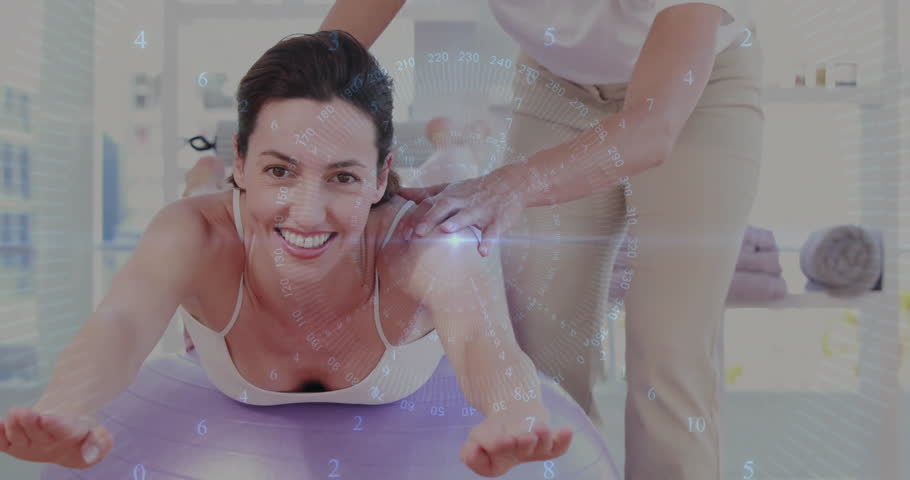 Woman stepping on purple ball, fitness trainer guiding alignment, doing back-extension for posture. Balance, strength, flexibility, rehabilitation, core, wellness, fitness