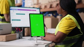 Warehouse employee in hi vis vest uses copy space display with technology of shipping software, packaging systems and inventory management tools. E-commerce logistics. Camera B. - Powered by Shutterstock - Get 15% off with code: PIKWIZARD15